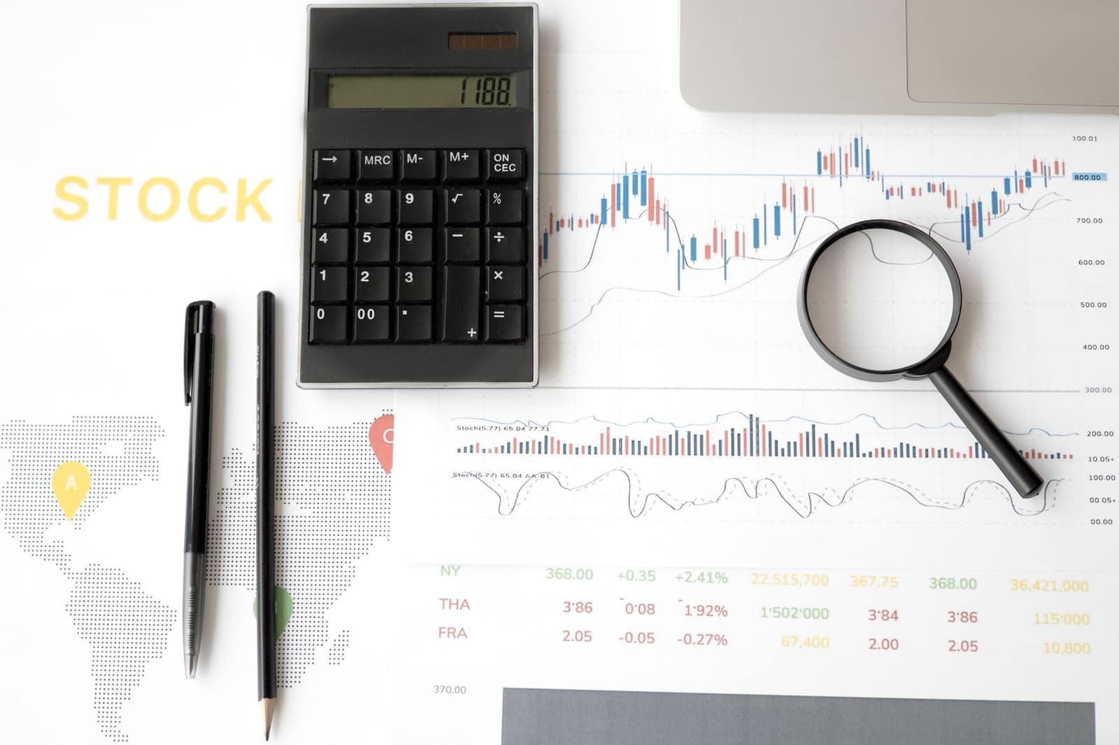 Financial documents, graphs and a calculator laid out on a desk