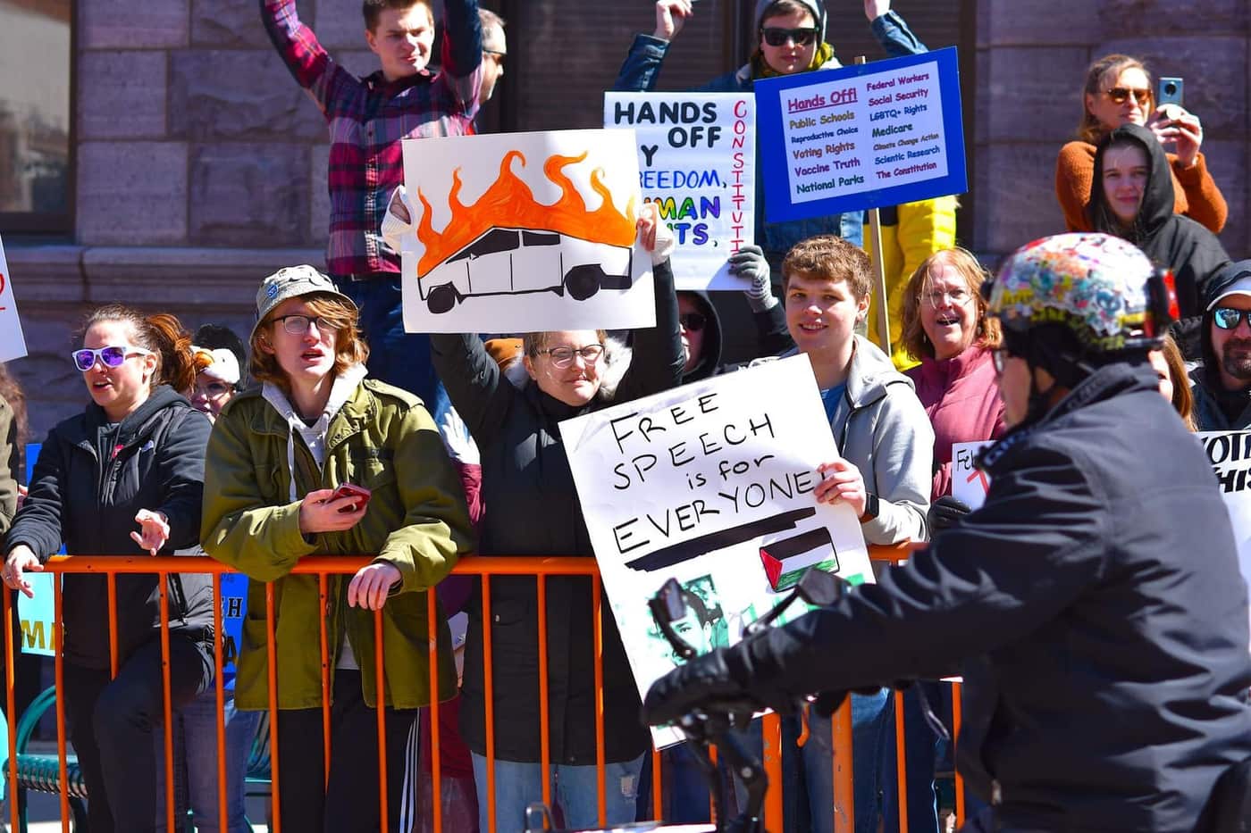 A large crowd of protesters holding signs at a street demonstration