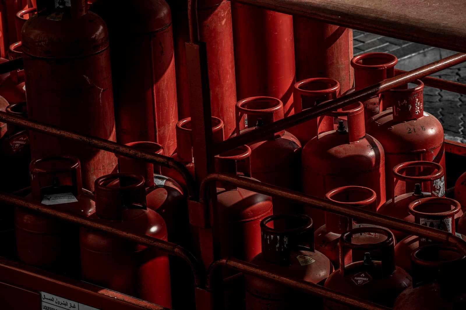 Rows of red gas cylinders stacked in an industrial storage yard