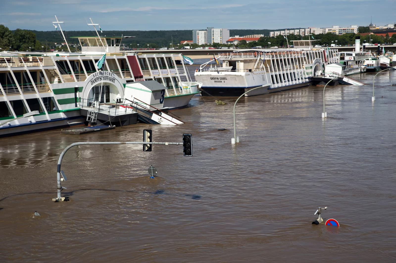 A flooded street with boats partially submerged after heavy rain