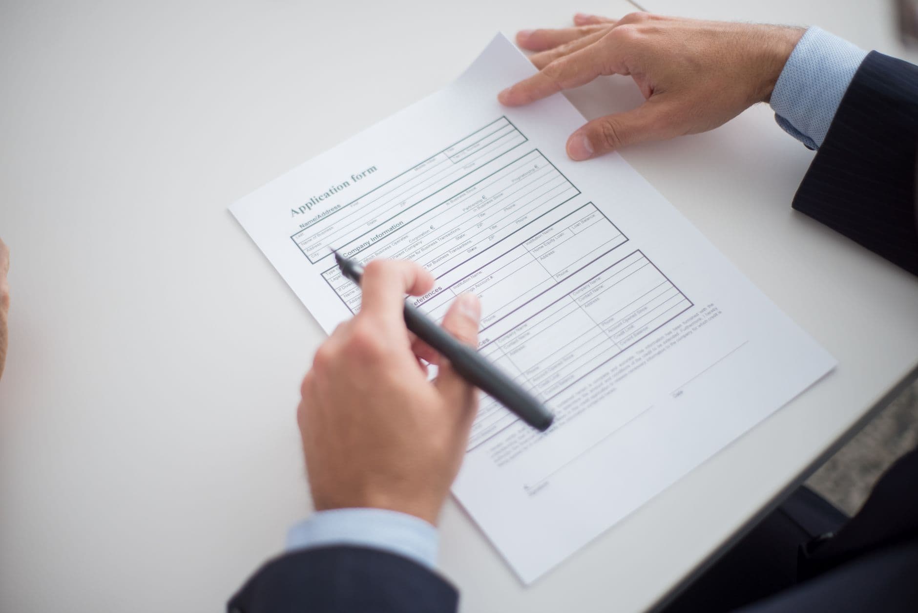 Close-up of a person reviewing an official application form at a desk