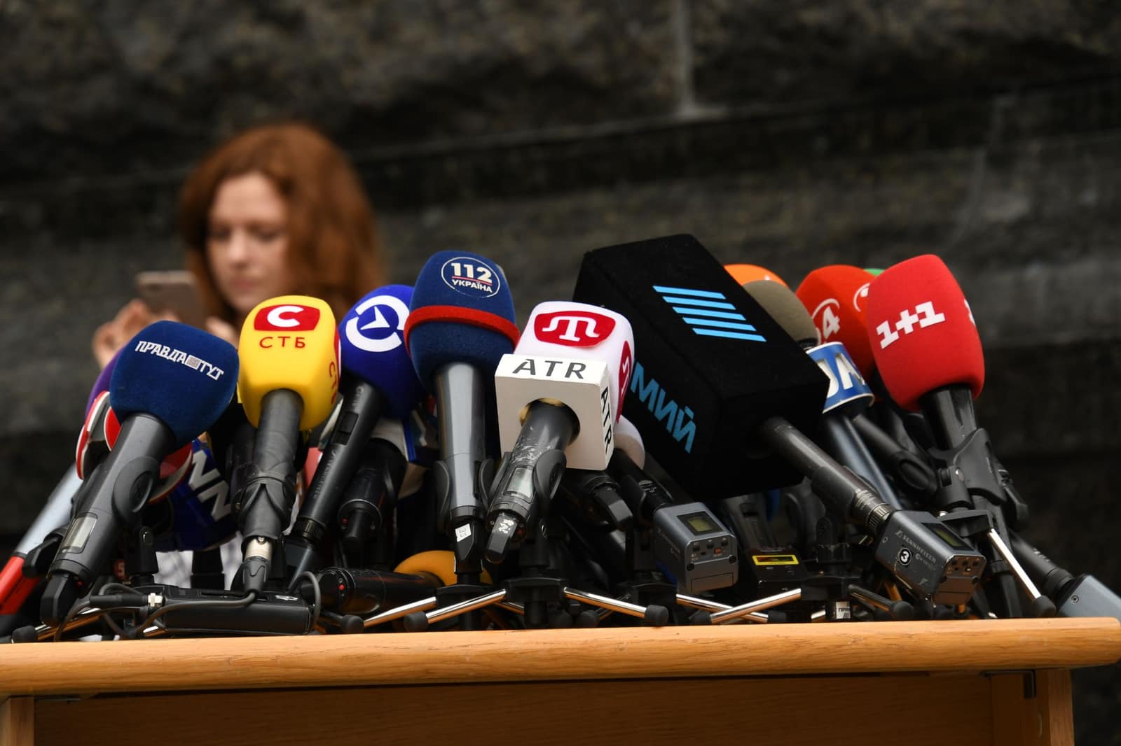 Rows of microphones set up at a podium for a press briefing