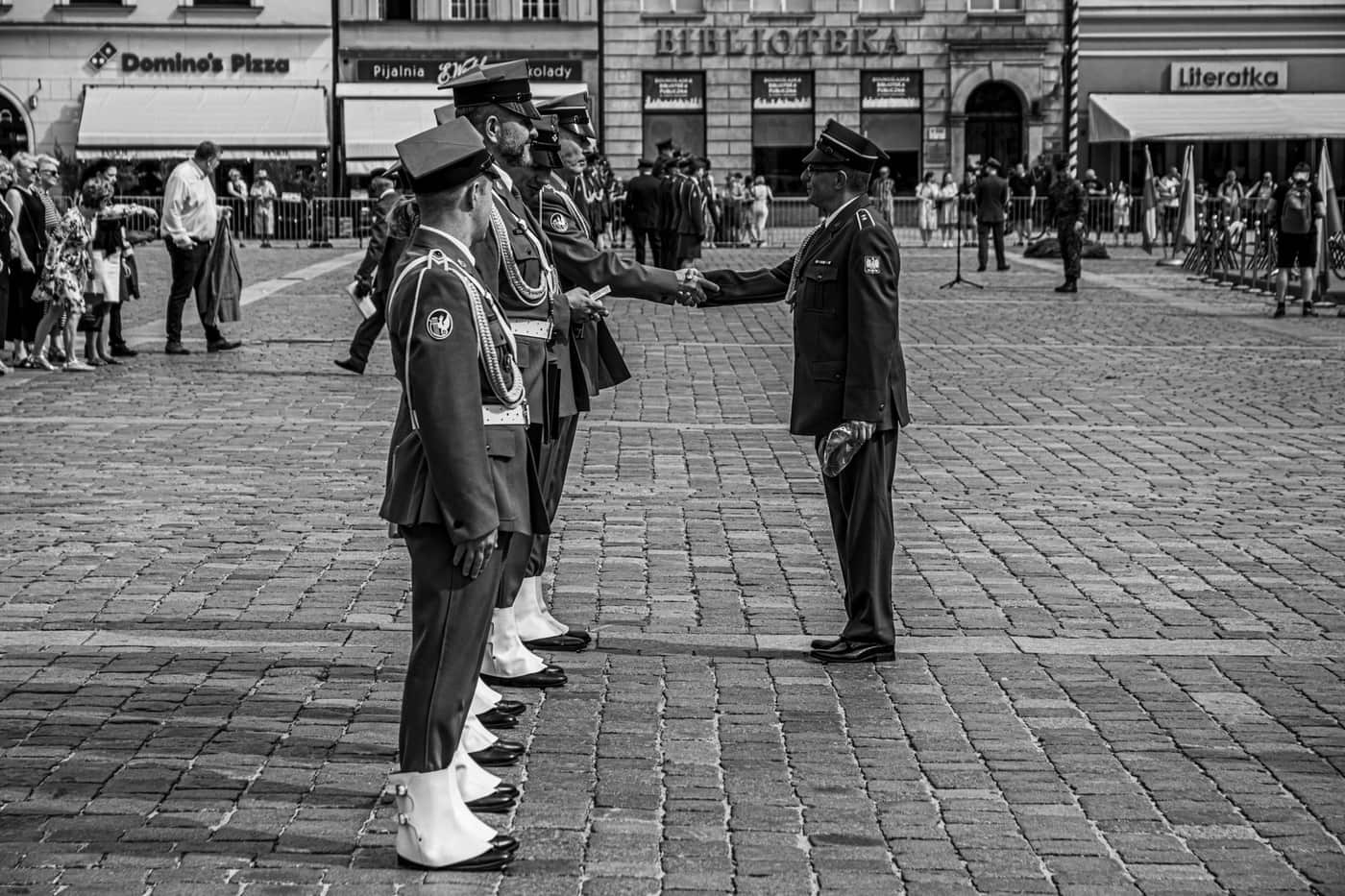 Formal handshake between uniformed military officers in a ceremonial setting