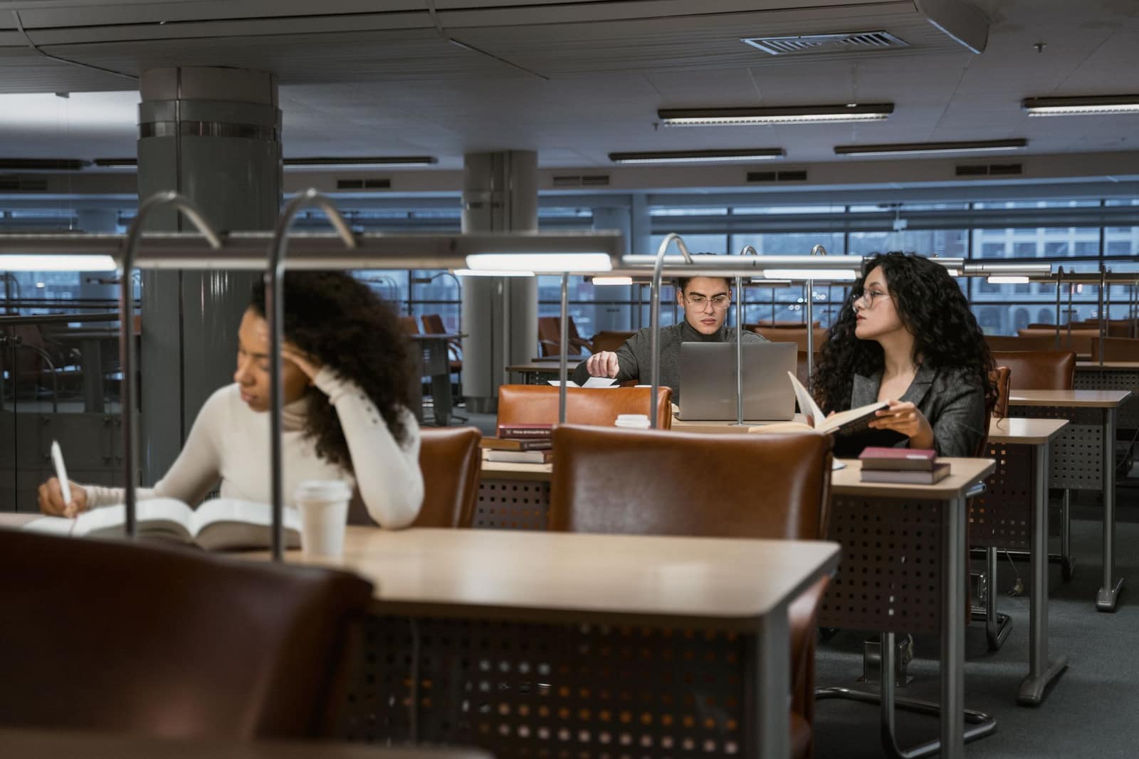 College students studying together at desks in a modern university library