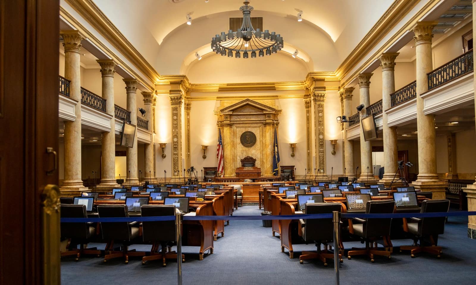 A grand government chamber with ornate columns and tiered seating