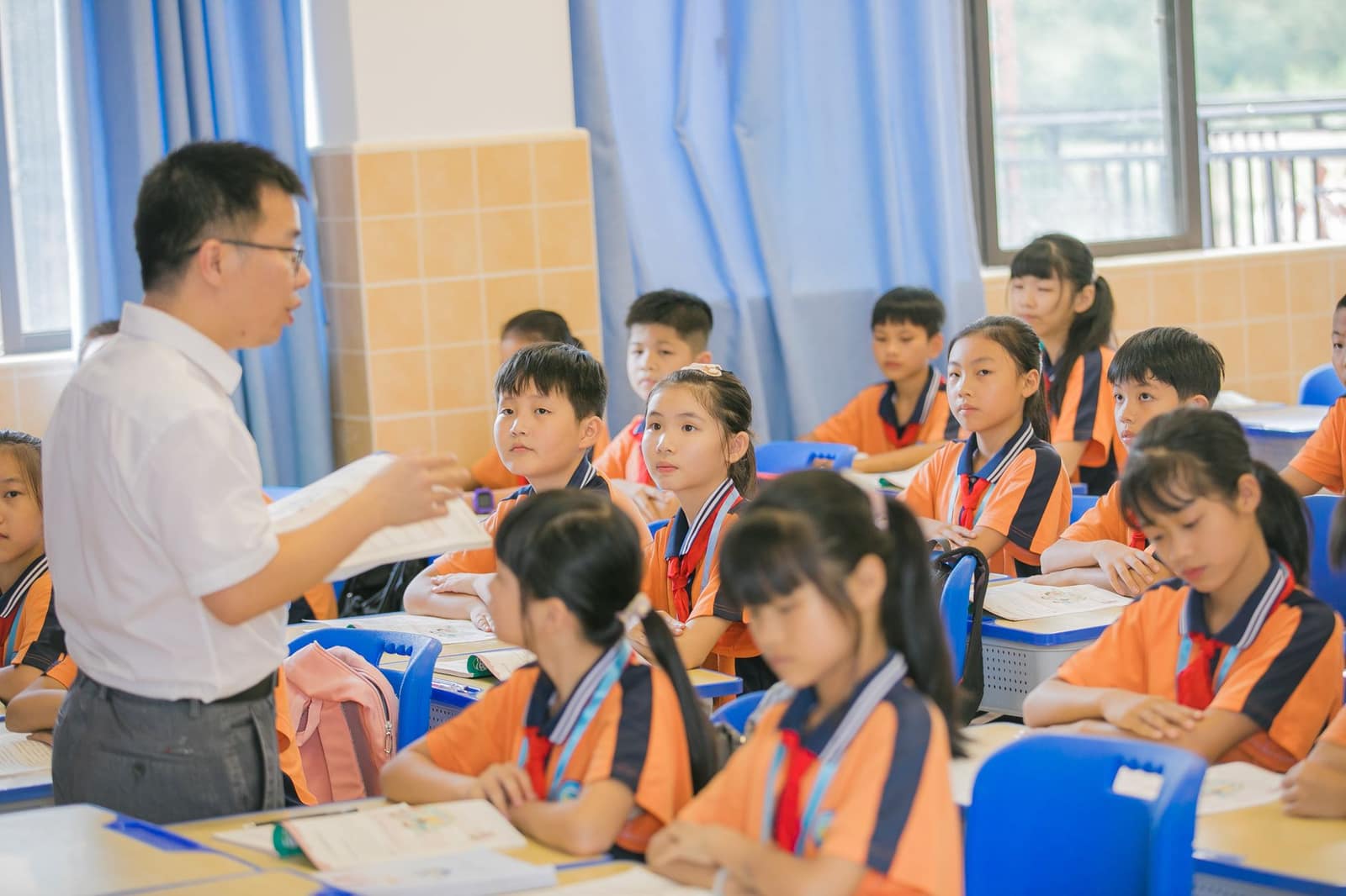 A teacher conducting a lesson with attentive students in a bright classroom