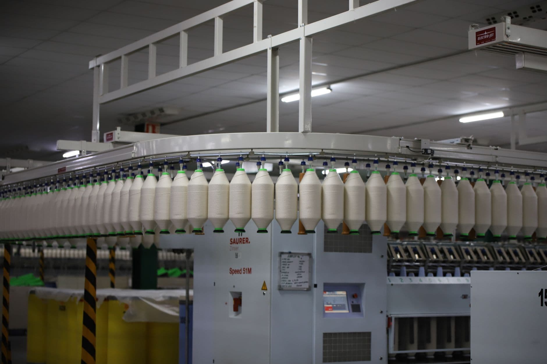 White cotton threads on spools inside a textile factory