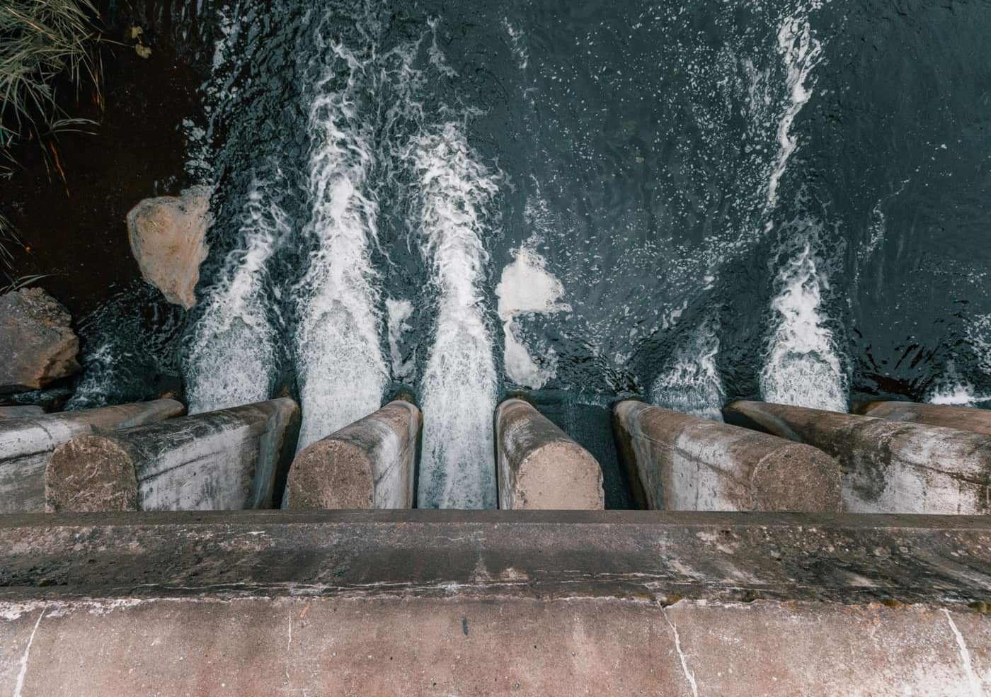 Aerial view of water flowing over a concrete dam