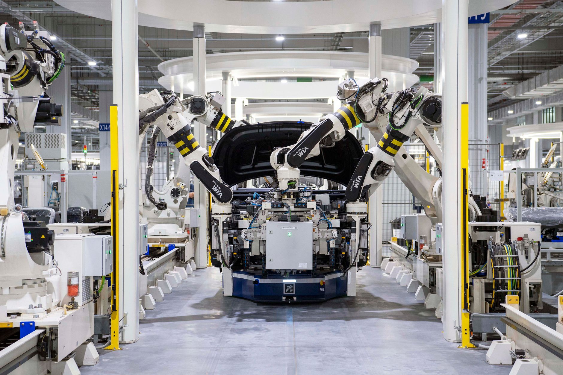 Robotic arms assembling a car on a factory production line