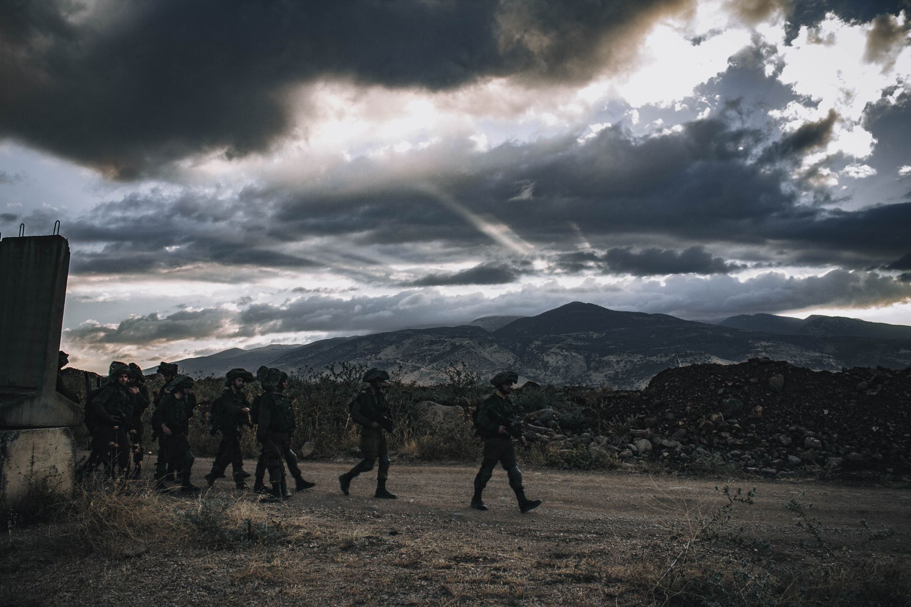 Soldiers in uniform walking across an open field