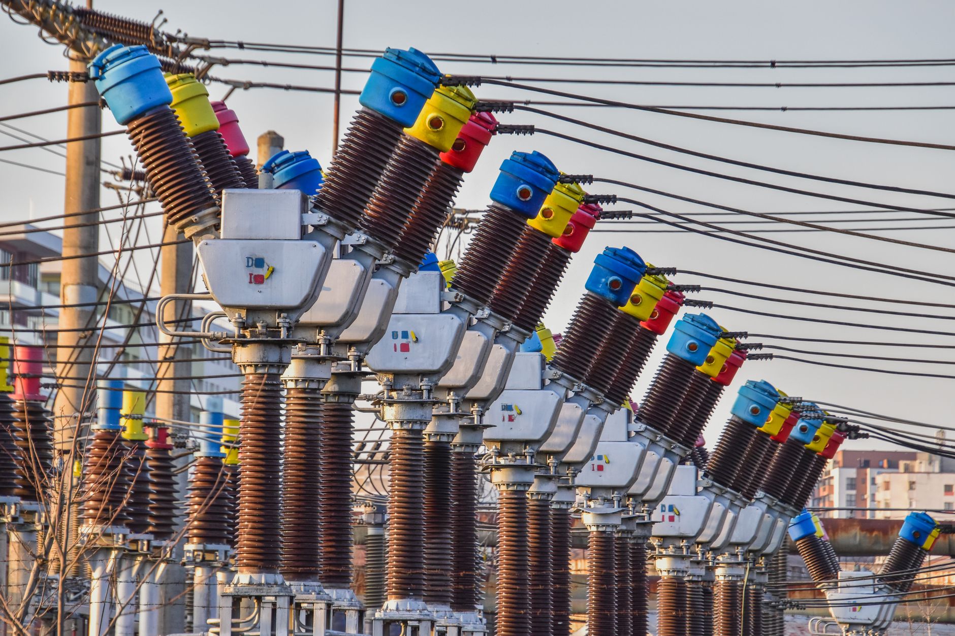 Multiple electrical transformers at an outdoor power substation in daylight