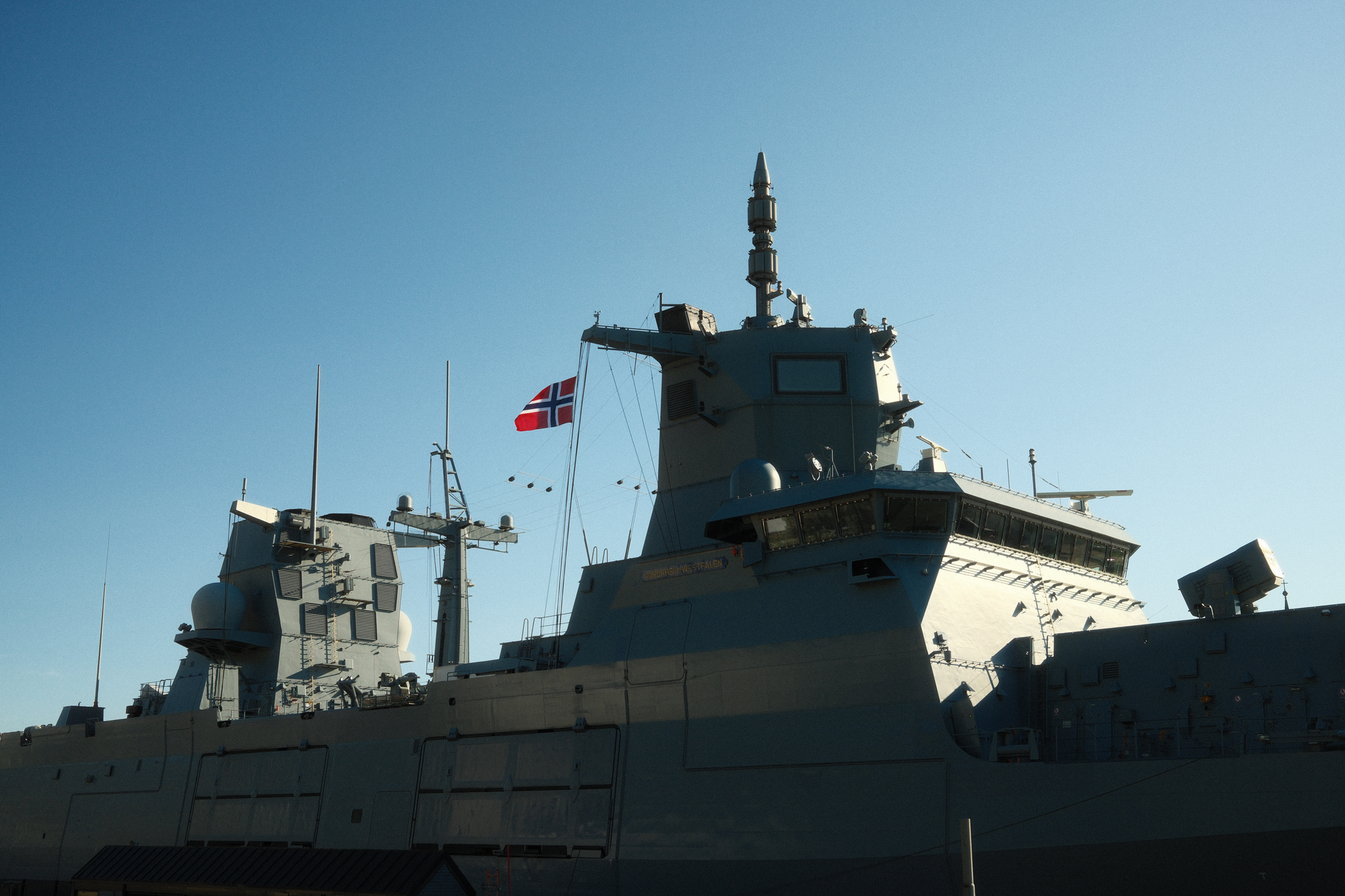 A naval warship with a flag at sea