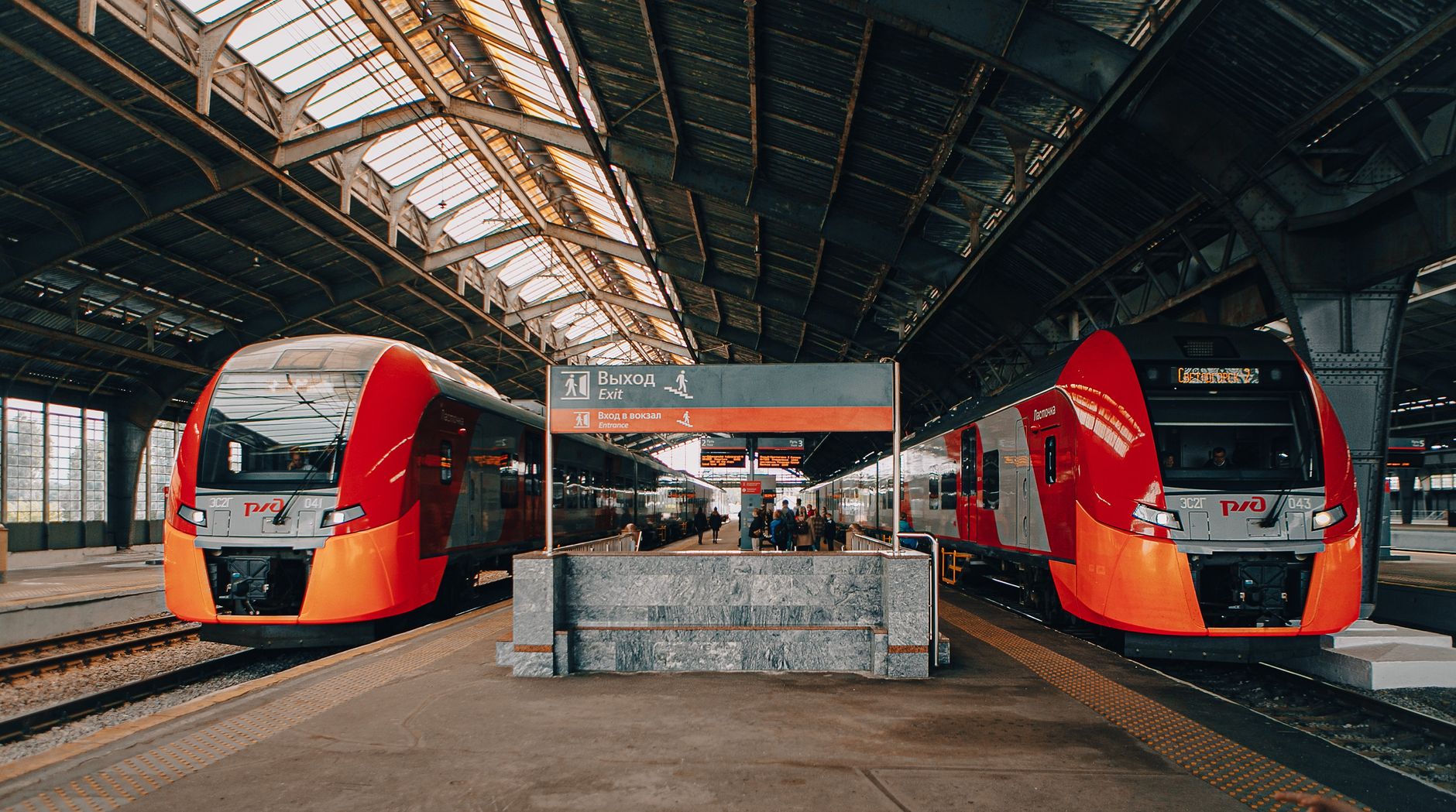 Trains at a busy railway station with passengers