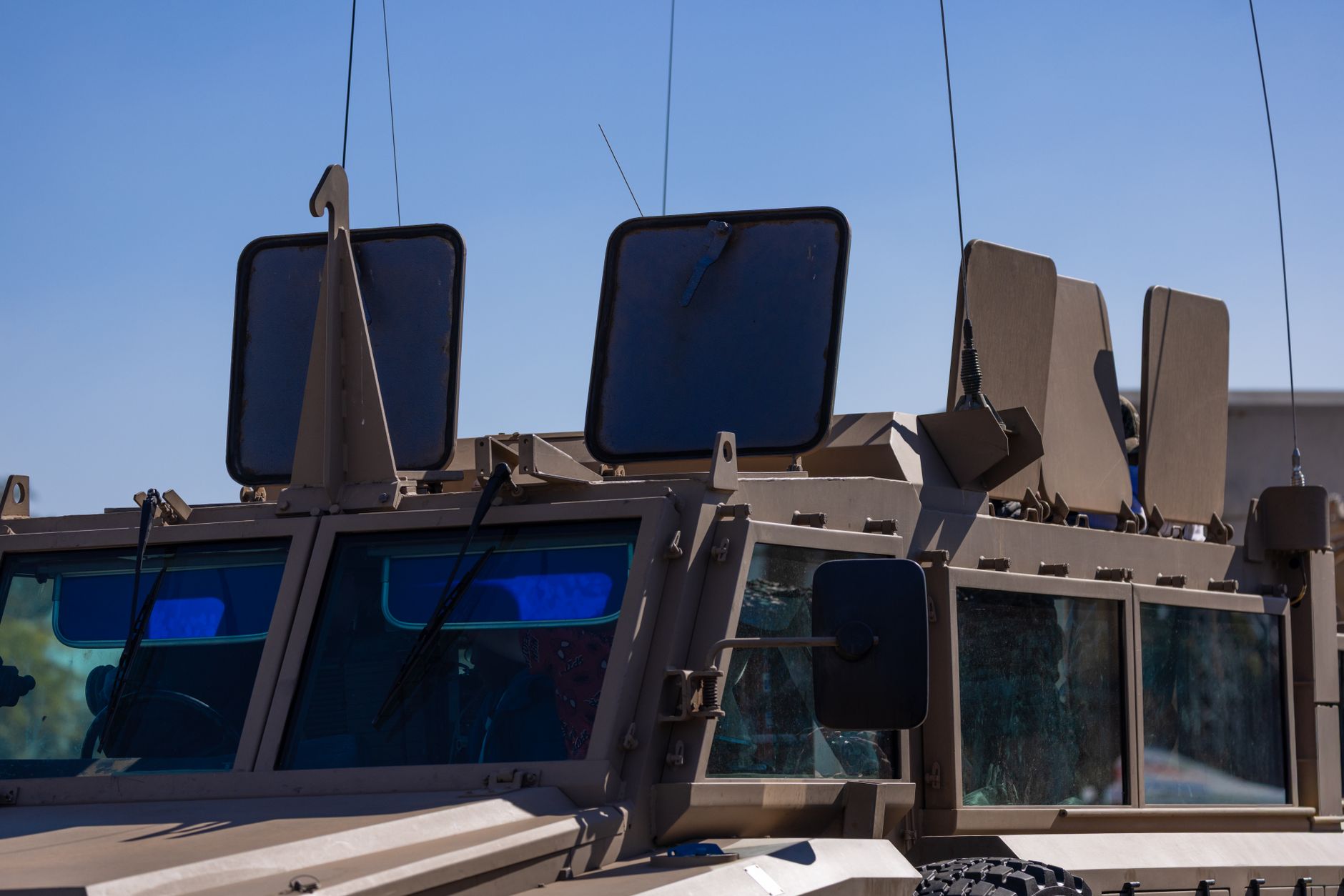 Close-up of an armored military vehicle's protective plating under a clear sky