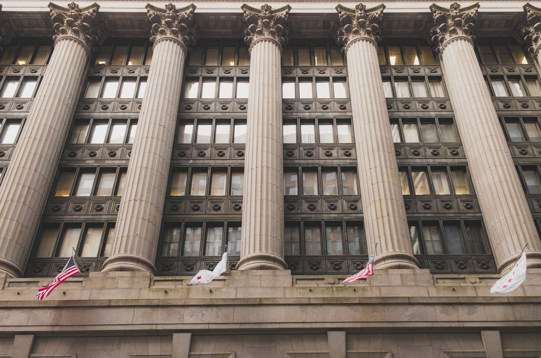 Neoclassical government building facade with columns and flags