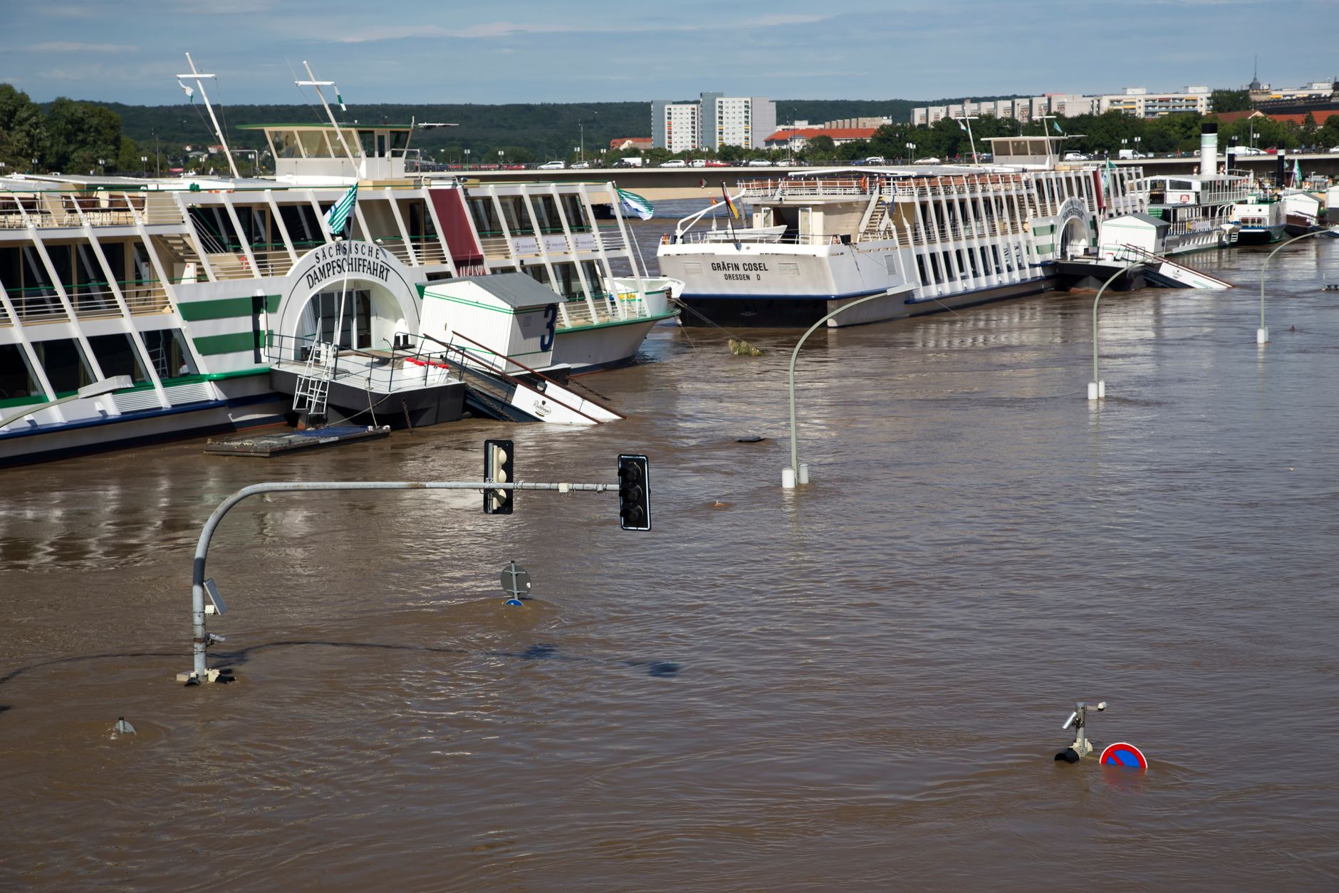 A flooded street with boats partially submerged after heavy rain