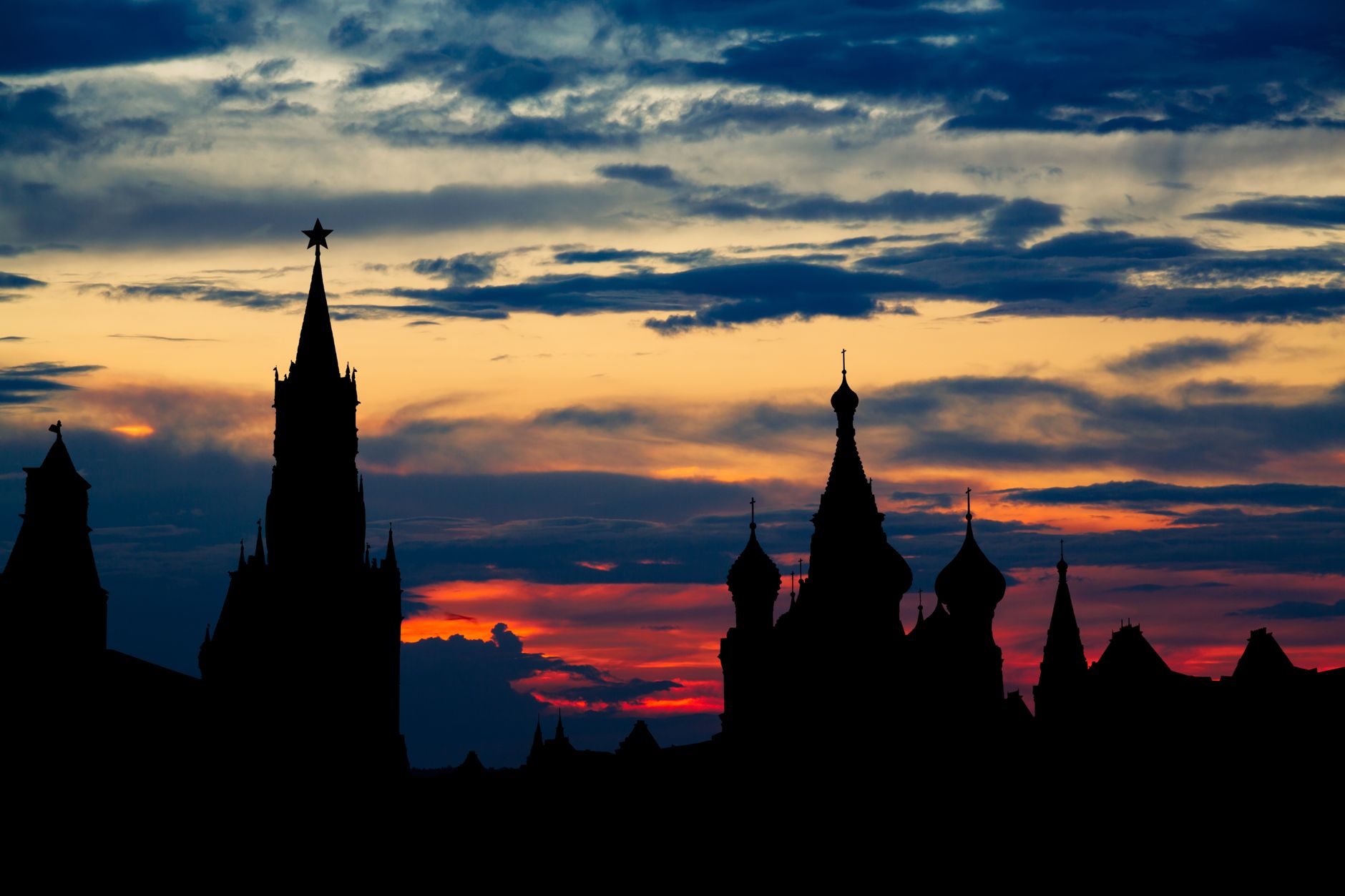 Dramatic silhouette of Moscow's Kremlin towers against a vivid sunset sky