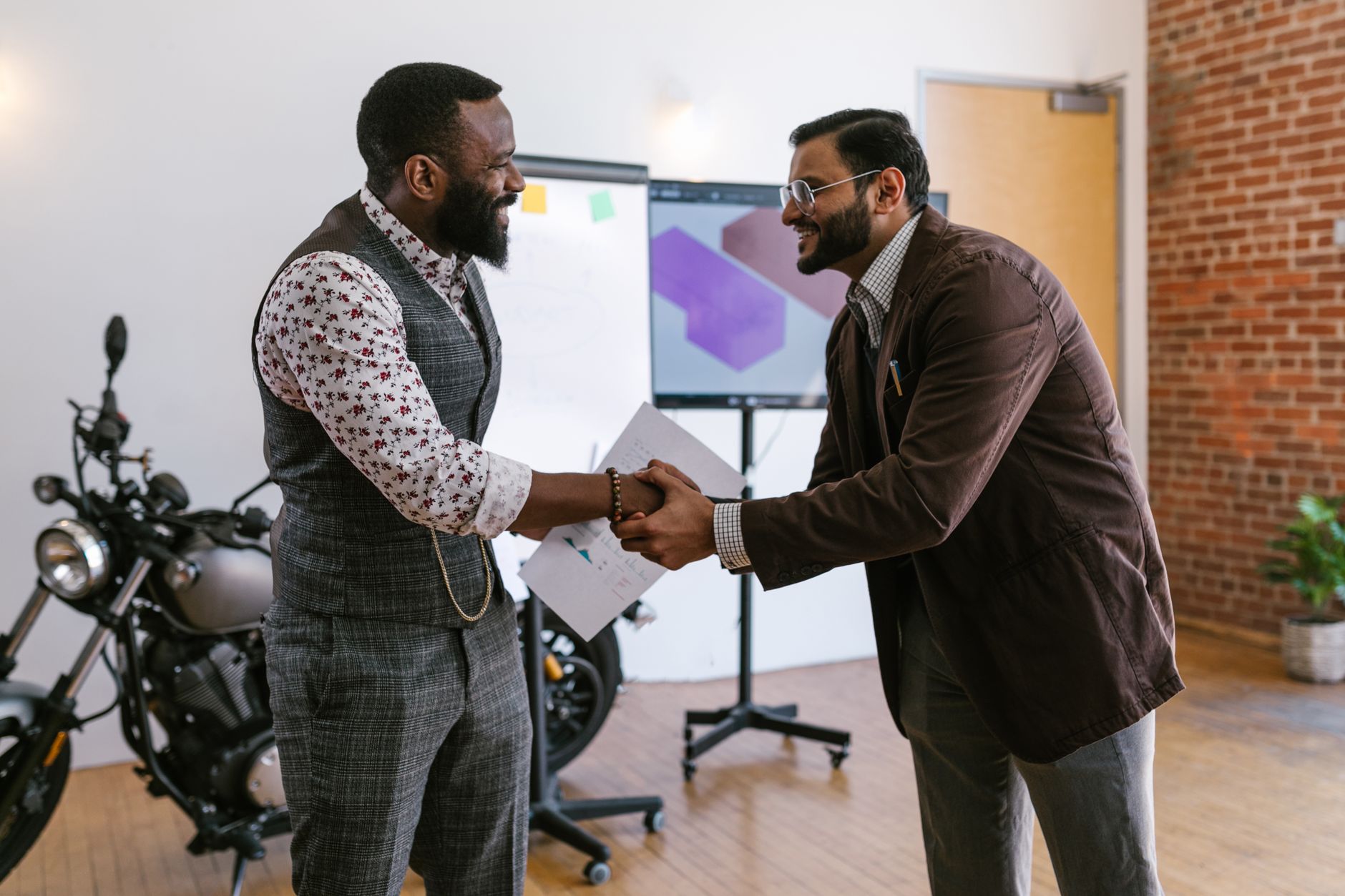 Two business professionals shaking hands in a modern office setting