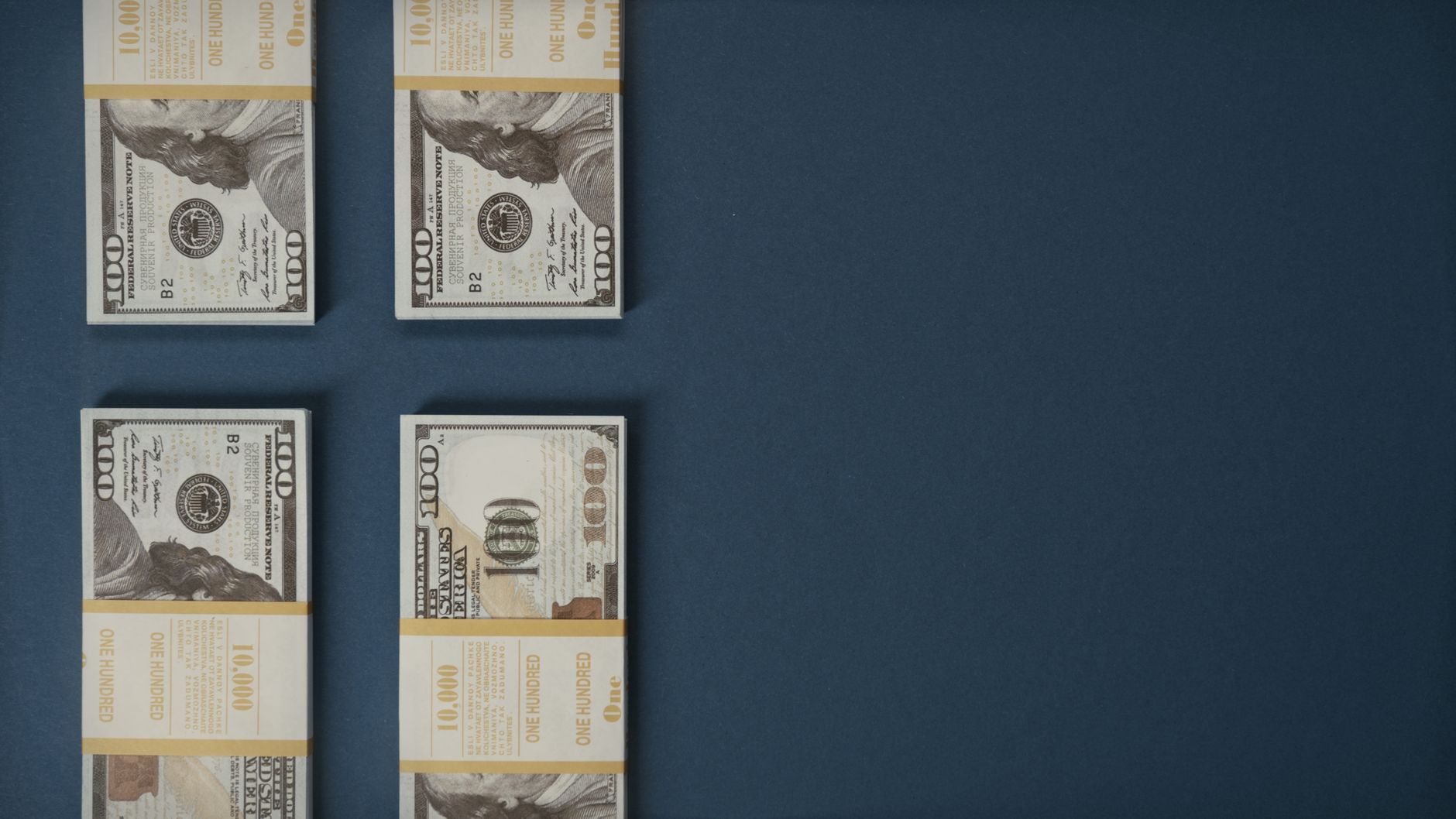 Bundles of US dollar banknotes stacked on a surface