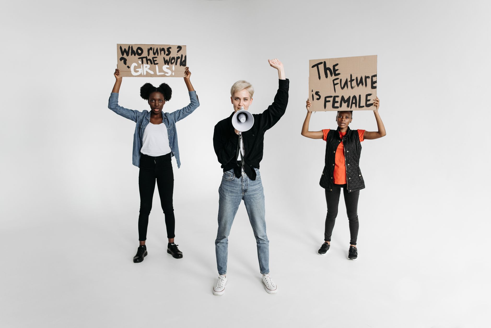 Three women holding protest signs about women's rights