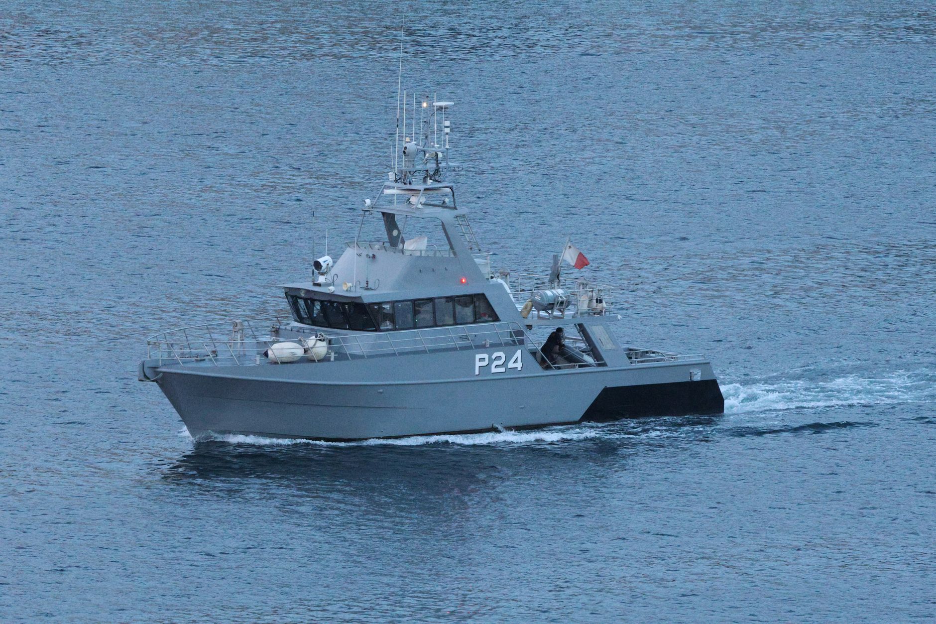A military patrol boat cruising through open ocean waters