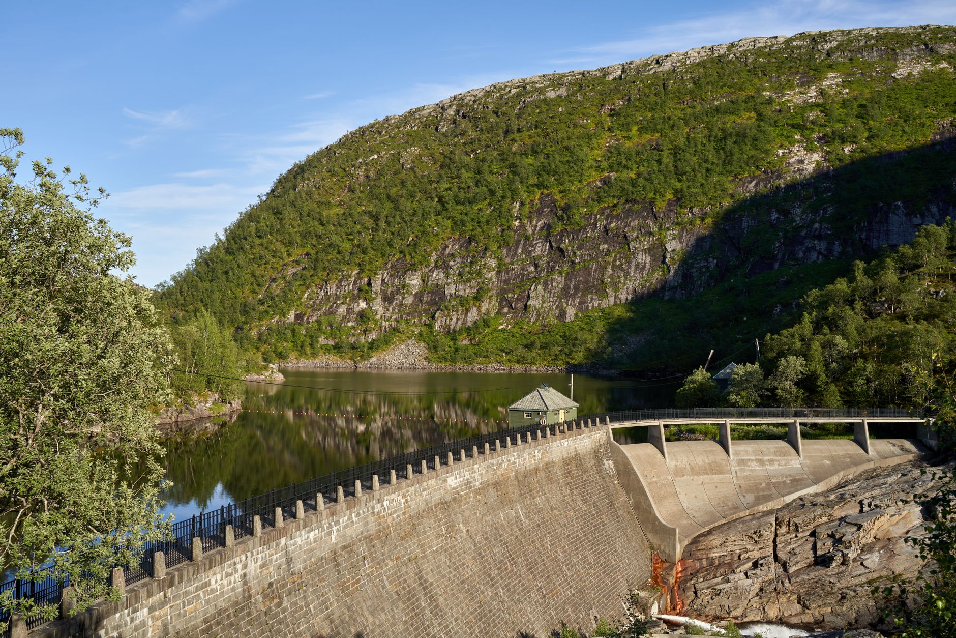 A water dam nestled in a mountainous landscape reflecting calm waters