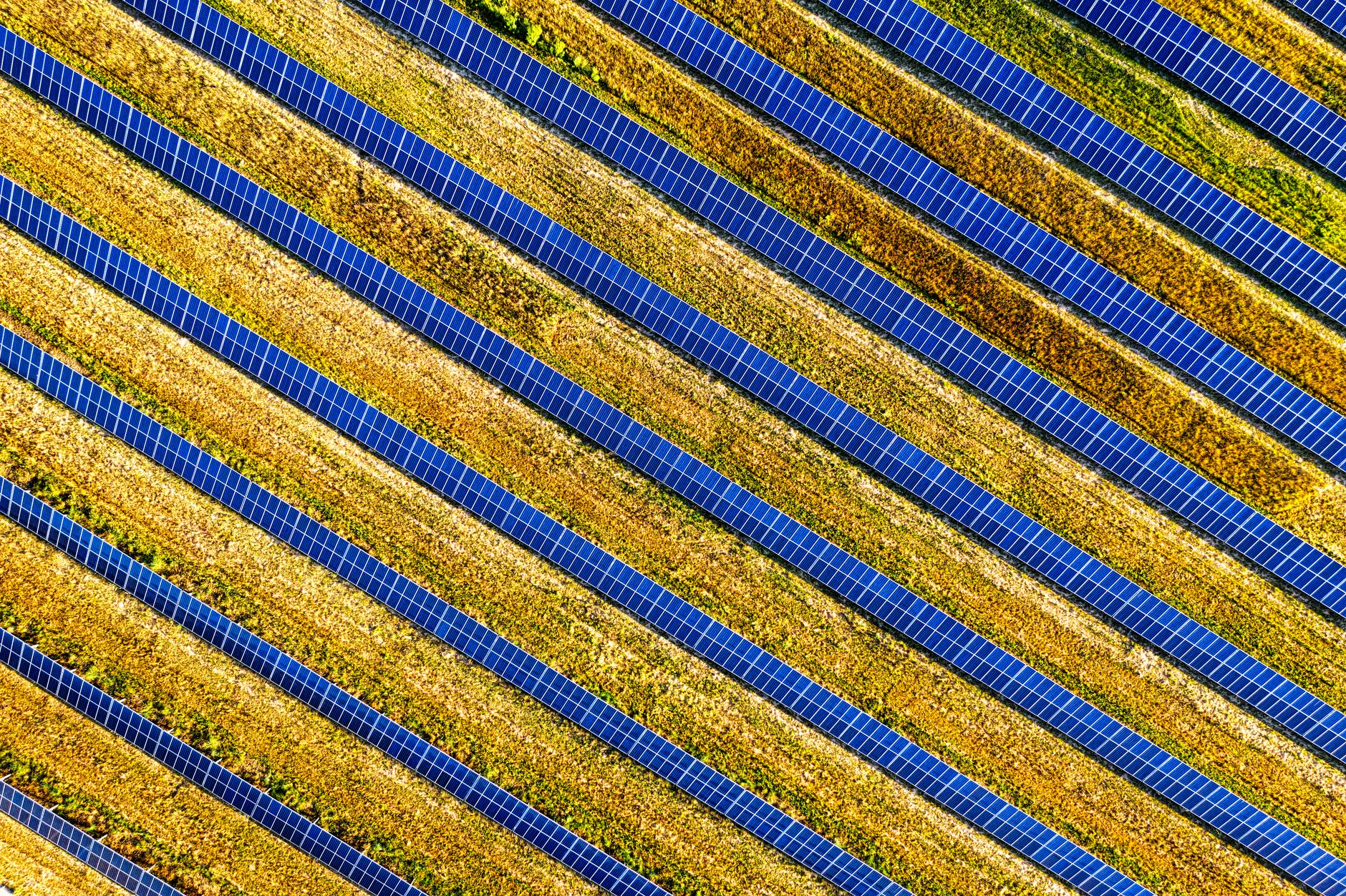 Aerial view of solar panels arranged in rows across an open field