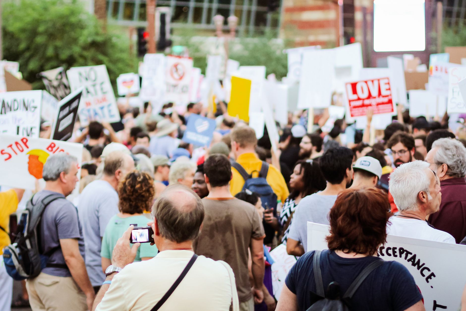 Back view of a crowd holding banners and placards at a public gathering