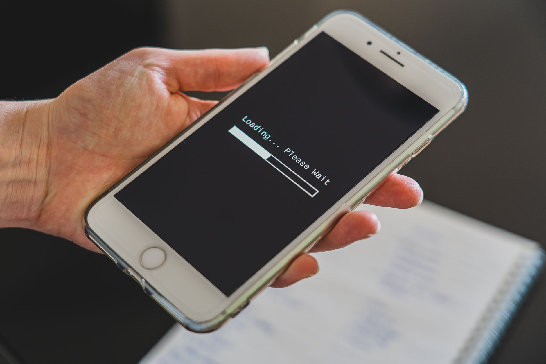 Close-up of a hand holding a smartphone with a loading screen displayed
