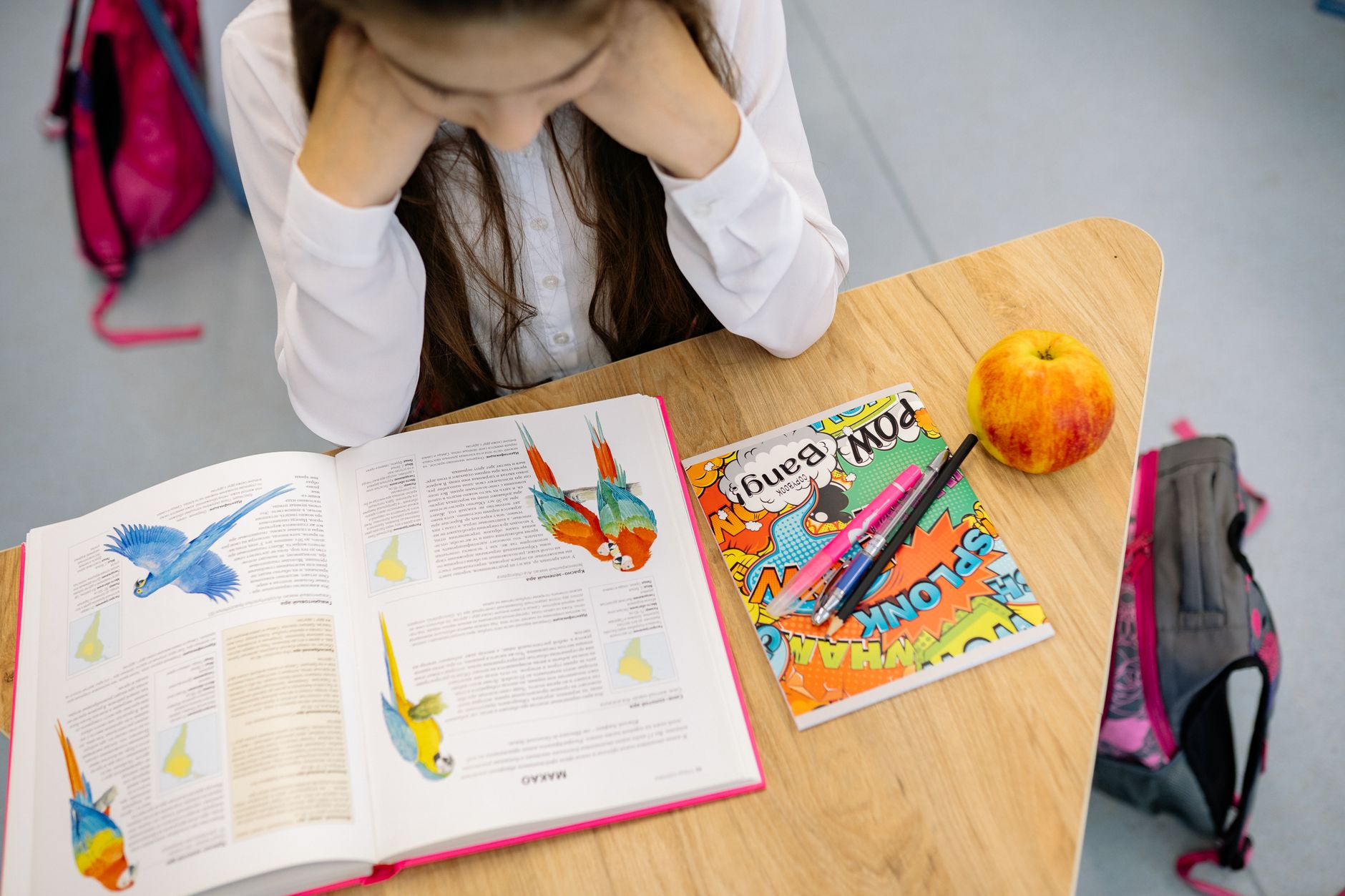 A student studying at a desk with a notebook and books