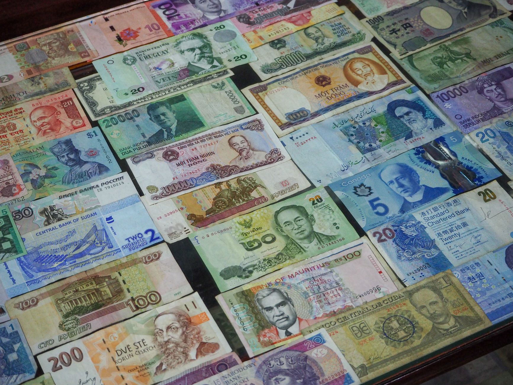 An overhead view of assorted foreign currency banknotes arranged in a row