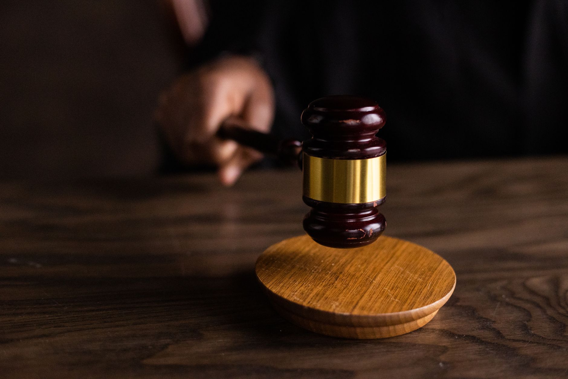 A gavel resting on a sound block on a wooden table