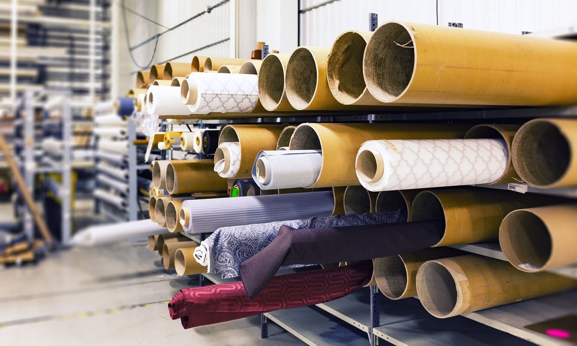 Rows of textile fabric rolls stored in a factory