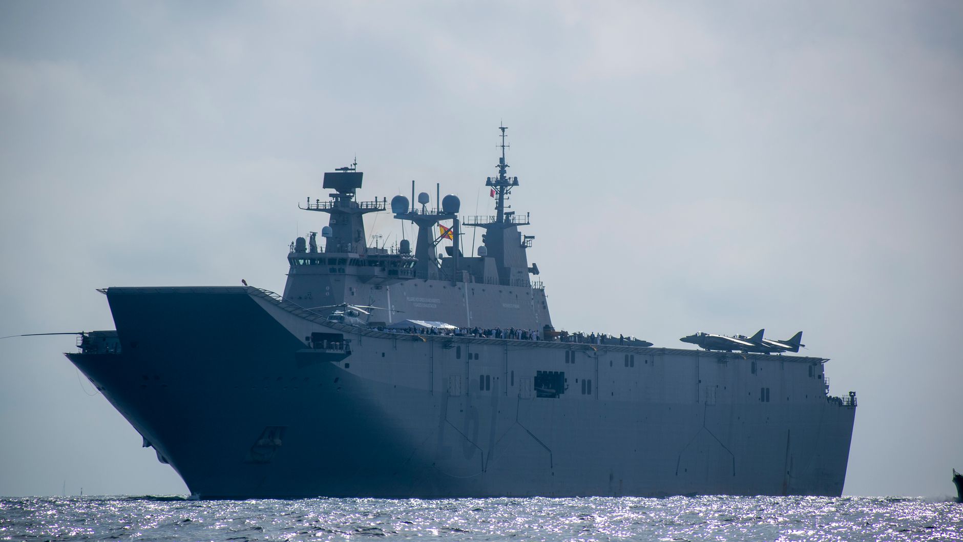 A powerful aircraft carrier sailing on the open sea under a clear sky